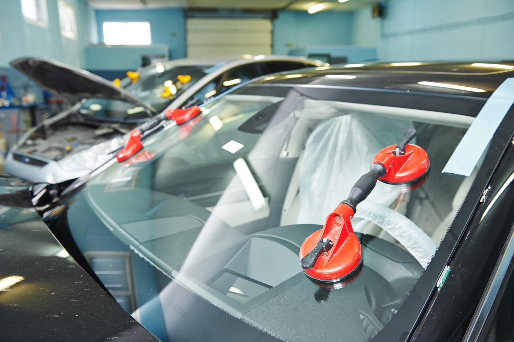 Automobile car windshield or windscreen service concept in auto service station garage